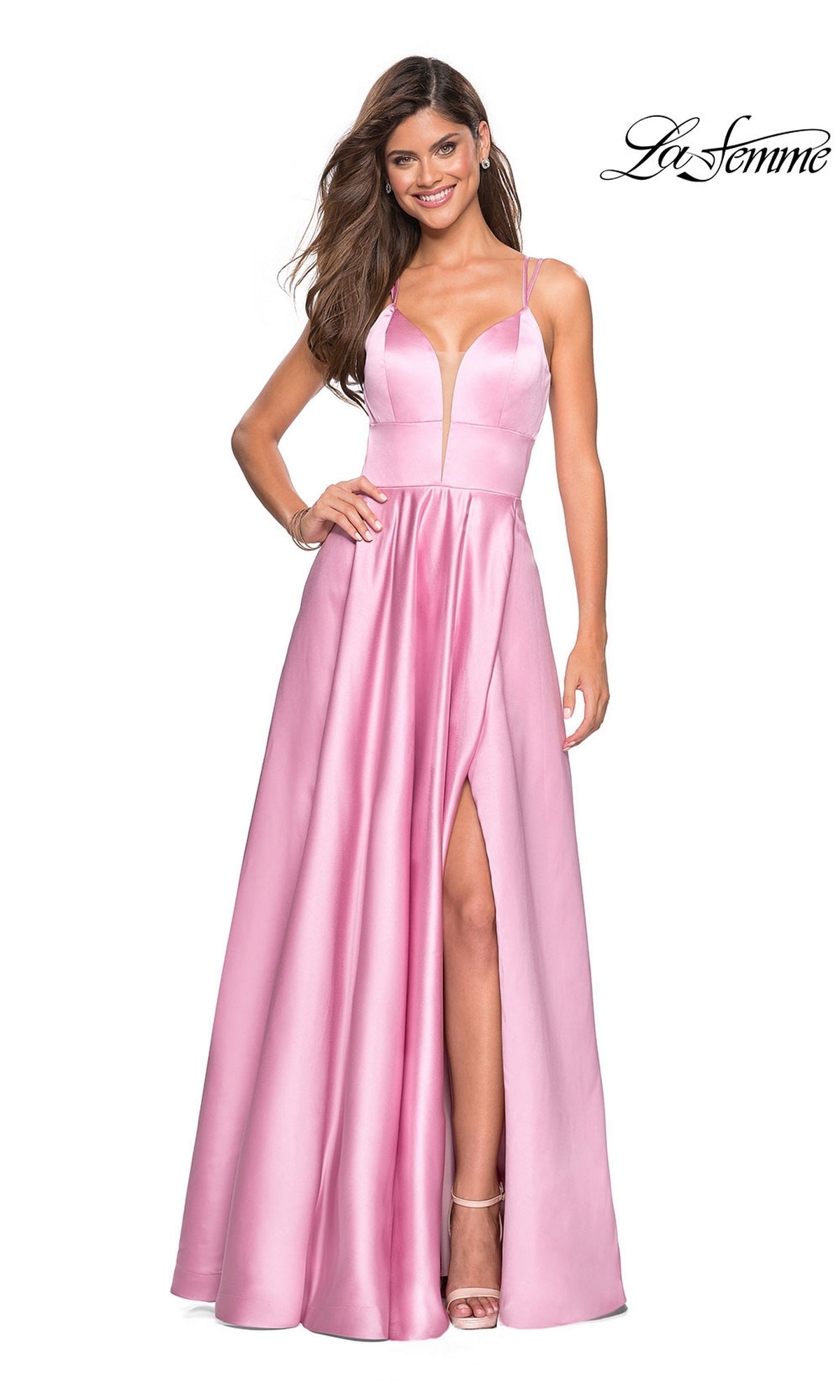A woman models the La Femme Deep V-Neck Long A-Line Prom Dress 26994 in blush satin, featuring thin straps, a deep V neckline, and a thigh-high slit, posed against a white background with the La Femme logo in the top right corner.